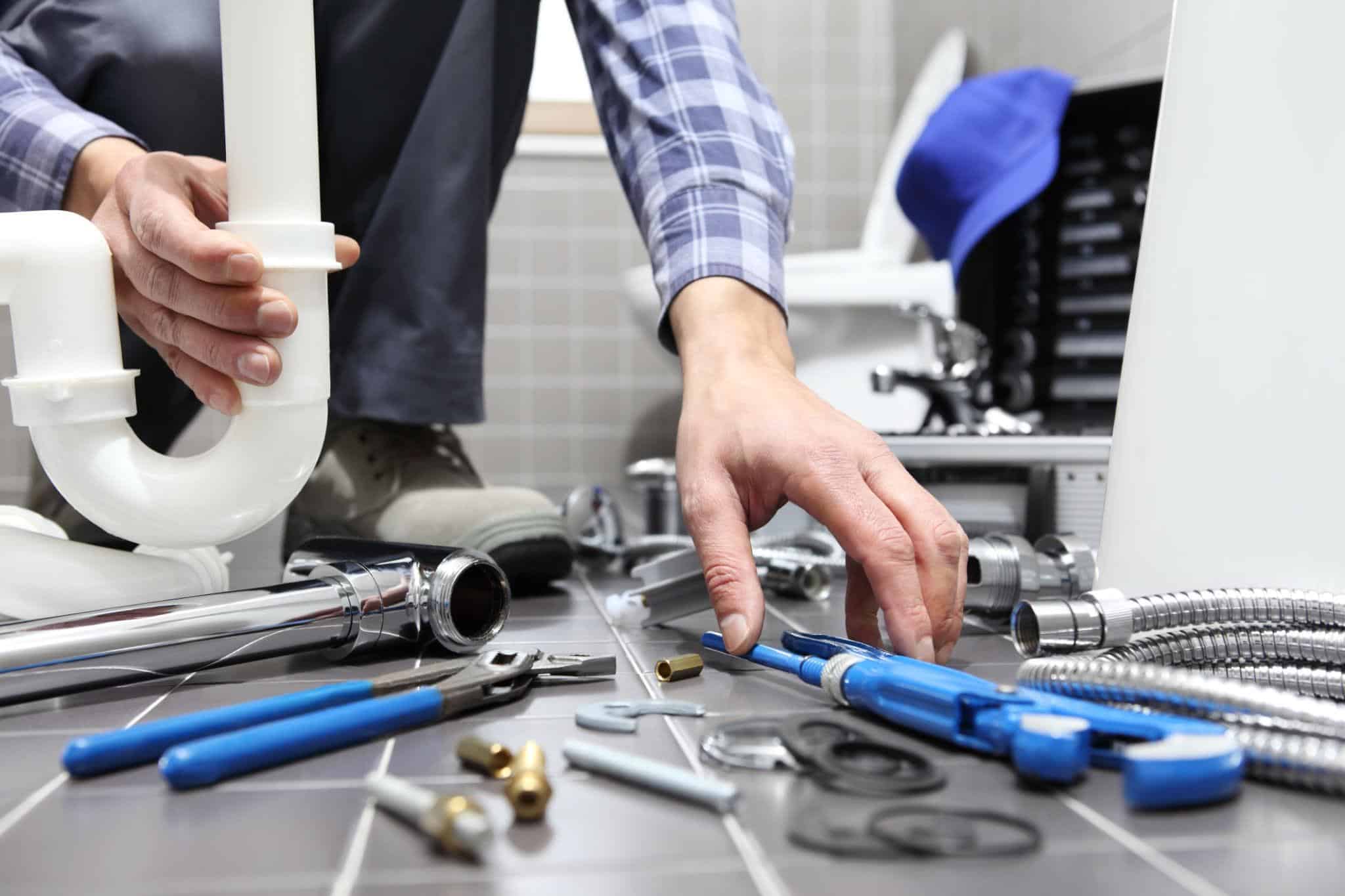 Professional plumber and electrician performing licensed bathroom renovation work safely