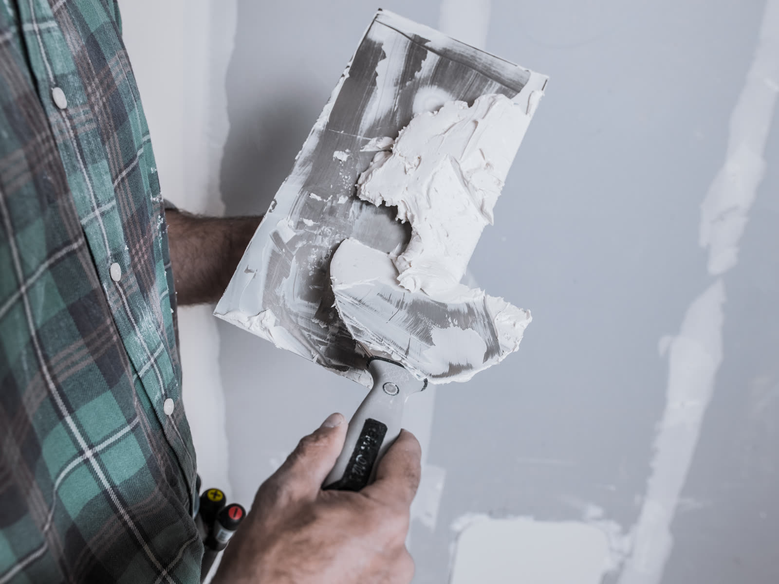 A mason prepares the putty with trowels to apply i — the kind of interior & exterior painting our vetted local pros handle in Sarasota, FL