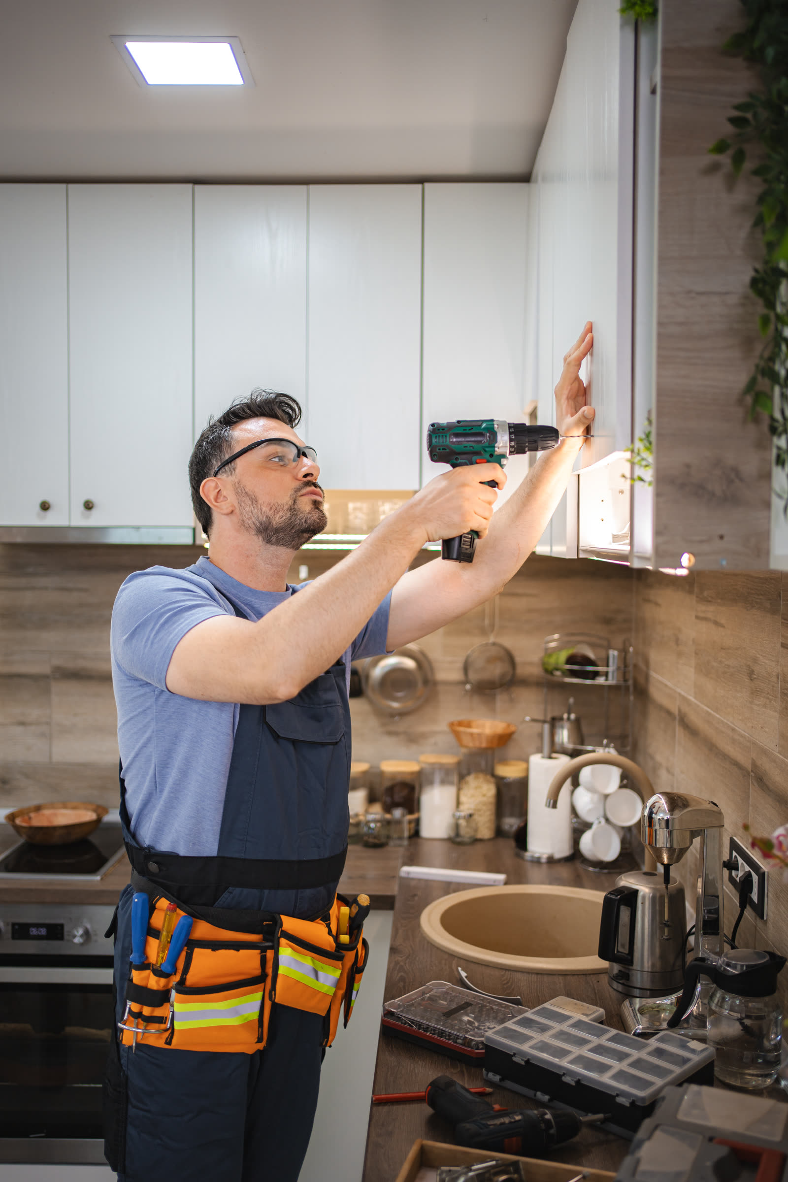 Handyman installing kitchen cabinets using a cordl — the kind of interior & exterior painting our vetted local pros handle in Sarasota, FL