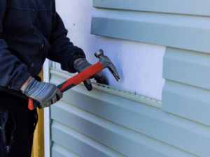 Repairing loose siding and soffits to prevent wind damage to home exterior